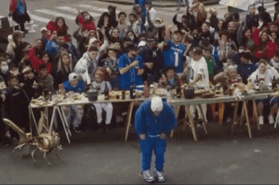 A Man Is Dancing In Front Of A Crowd Of People . GIF
