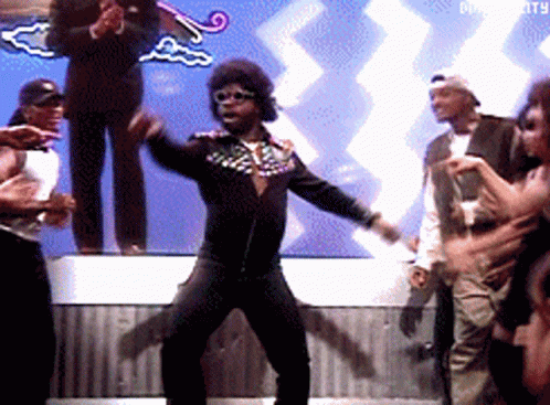 A Man Is Dancing In Front Of A Crowd With A Sign That Says Diversity GIF