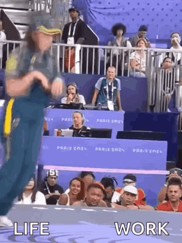 A Man Is Dancing In Front Of A Crowd With The Words Life And Work Written Below Him . GIF