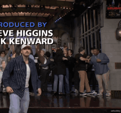 A Man Is Dancing In Front Of A Crowd With The Words Produced By Eve Higgins K Kenward GIF