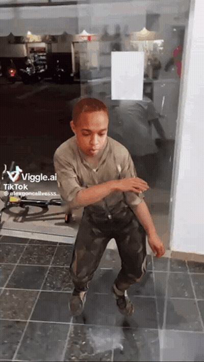 A Man Is Dancing In Front Of A Glass Door With A Tiktok Watermark On The Bottom Right GIF