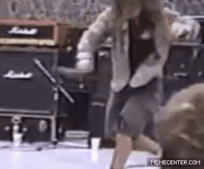 A Man Is Dancing In Front Of A Marshall Amplifier . GIF