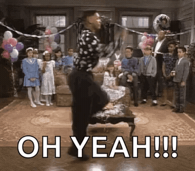 a man is dancing in front of a microphone in a living room while a group of children watch .