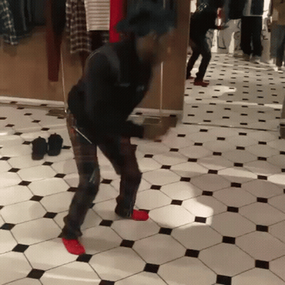 A Man Is Dancing In Front Of A Mirror In A Room GIF