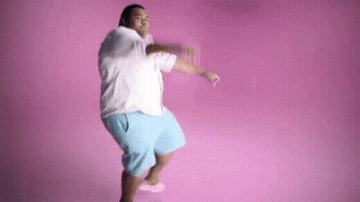 A Man Is Dancing In Front Of A Pink Background . GIF