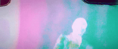 A Man Is Dancing In Front Of A Pink Wall In A Room . GIF