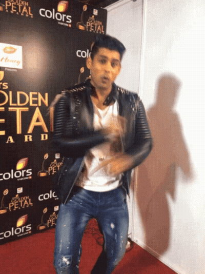 A Man Is Dancing In Front Of A Sign That Says Golden Petal GIF