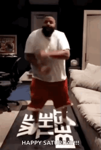 A Man Is Dancing In Front Of A Sign That Says `` Happy Saturday ! '' GIF
