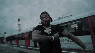A Man Is Dancing In Front Of A Train That Says R-Nl GIF