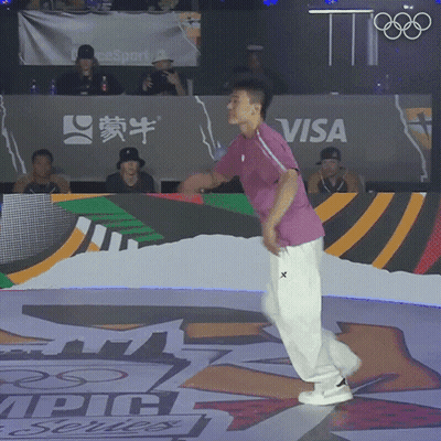 A Man Is Dancing In Front Of A Visa Banner GIF
