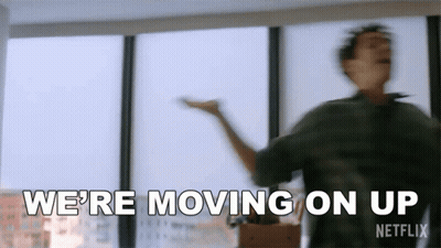 A Man Is Dancing In Front Of A Window In A Room And Saying `` We 'Re Moving On Up '' . GIF