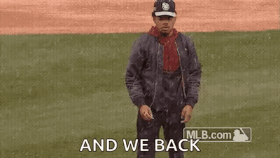 A Man Is Dancing On A Baseball Field While Wearing A Hat And A Jacket . GIF