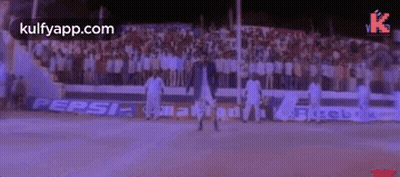 A Man Is Dancing On A Basketball Court In Front Of A Crowd Of People . GIF