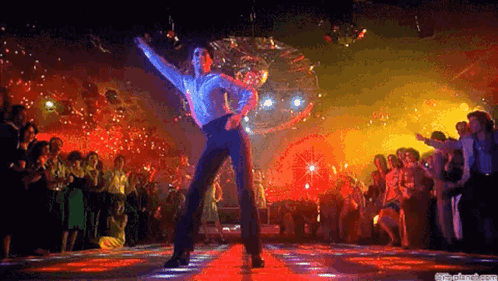 A Man Is Dancing On A Dance Floor In Front Of A Crowd Of People . GIF