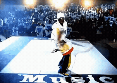 A Man Is Dancing On A Dance Floor In Front Of A Crowd With The Word Music Written On The Floor GIF