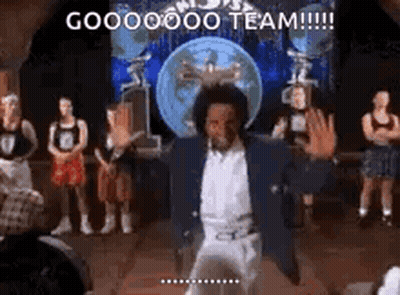 A Man Is Dancing On A Stage In Front Of A Group Of People And A Globe . GIF