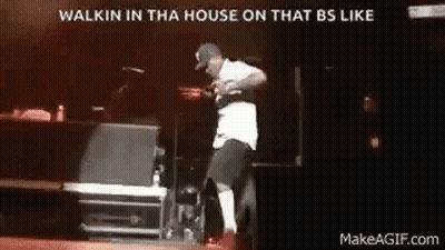 A Man Is Dancing On A Stage In Front Of A Microphone . GIF