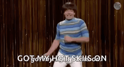 A Man Is Dancing On A Stage With The Words `` Got My Hot Skills On '' Behind Him . GIF