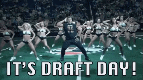 A Man Is Dancing With A Group Of Cheerleaders On A Field . GIF