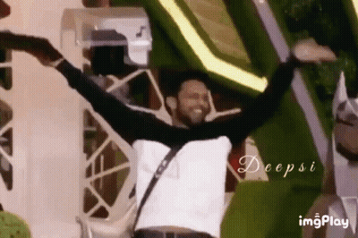 A Man Is Dancing With His Arms Outstretched In Front Of A Crowd . GIF