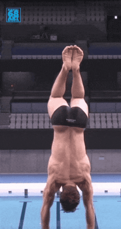 A Man Is Doing A Handstand In A Pool With A Speedo Logo On The Bottom Right GIF