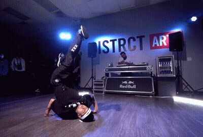 A Man Is Doing A Handstand In Front Of A Sign That Says District Ar GIF