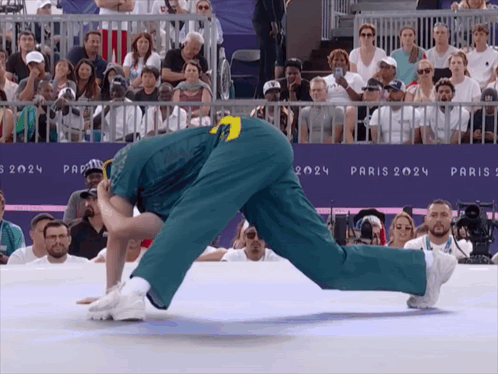 A Man Is Doing A Handstand In Front Of A Sign That Says Paris 2024 On It GIF