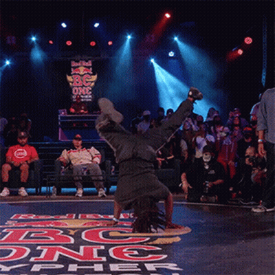 A Man Is Doing A Handstand In Front Of A Sign That Says Red Bull On It GIF
