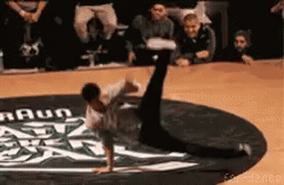 A Man Is Doing A Handstand On A Dance Floor With A Braun Logo In The Background GIF
