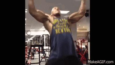 A Man Is Doing A Pull Up In A Gym Wearing A New York Shirt . GIF