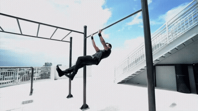 A Man Is Doing A Pull Up On A Bar Outside GIF