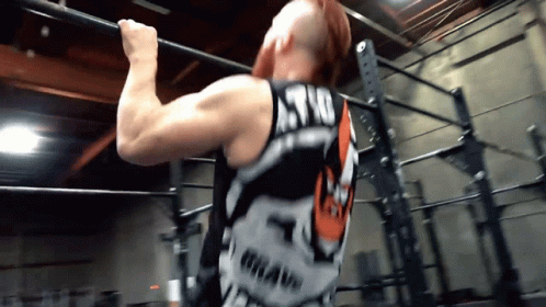 A Man Is Doing A Pull Up While Wearing A Shirt That Says Astro GIF
