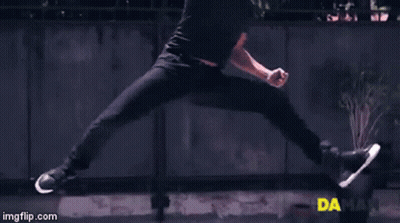 A Man Is Doing A Trick In Front Of A Fence And A Sign That Says Daman GIF