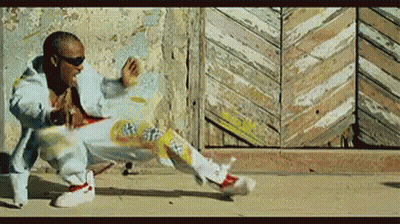 A Man Is Doing A Trick On A Skateboard In Front Of A Wall GIF