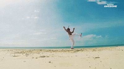 A Man Is Doing A Yoga Pose On A Beach With The Words Awesome Behind Him GIF