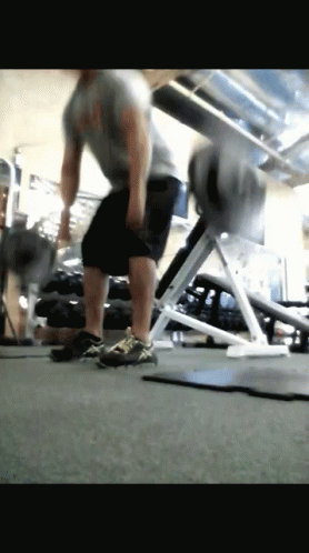 A Man Is Doing Exercises In A Gym GIF