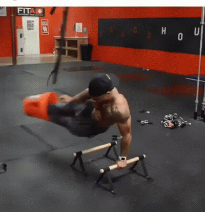 A Man Is Doing Exercises In A Gym With A Sign That Says Fit GIF