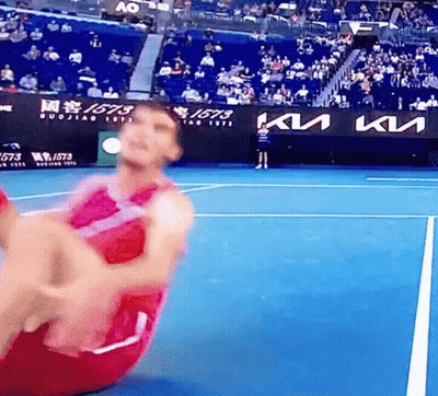 A Man Is Doing Sit Ups On A Tennis Court With A Kia Sign In The Background . GIF