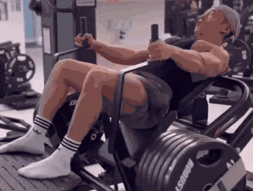 A Man Is Doing Squats On A Machine That Says ' Goalst ' On It GIF