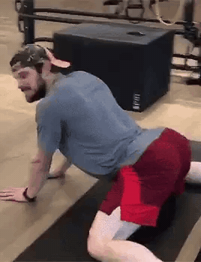 A Man Is Doing Stretching Exercises On A Yoga Mat . GIF