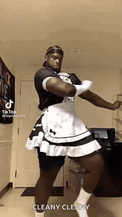 A Man Is Dressed As A Maid And Dancing In A Kitchen . GIF