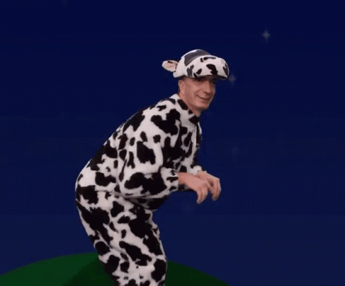 A Man Is Dressed In A Cow Costume And Hat GIF