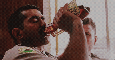 A Man Is Drinking From A Bottle That Says Busch GIF