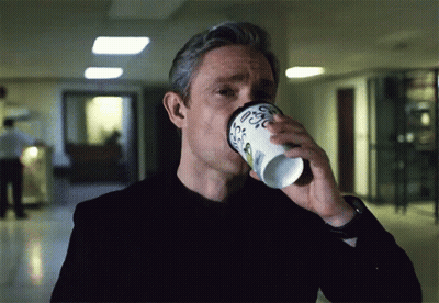 A Man Is Drinking From A Cup That Says Coffee GIF