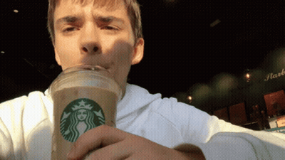 A Man Is Drinking From A Starbucks Cup With A Woman On It GIF