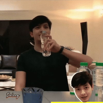 A Man Is Drinking Water From A Bottle With The Word Bolenj On The Bottom GIF