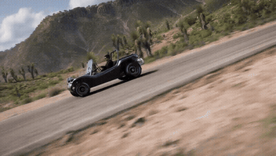 A Man Is Driving A Buggy Down A Dirt Road In The Desert GIF