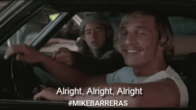 A Man Is Driving A Car And Pointing At The Camera While Another Man Sits Behind Him . GIF
