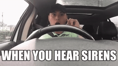 A Man Is Driving A Car And Talking On A Cell Phone With The Words `` When You Hear Sirens '' Above Him . GIF