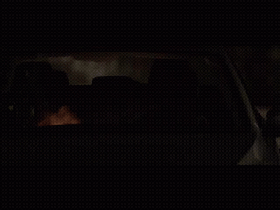 A Man Is Driving A Car At Night With His Head Out The Window GIF